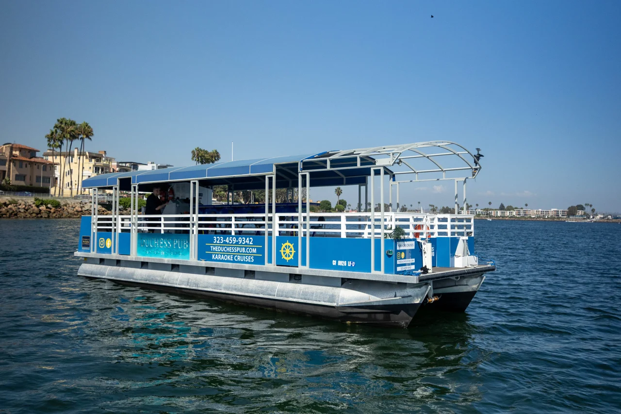 The open front deck and blue canopy of The Duchess Pub on the harbor
